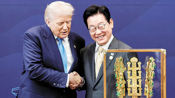   トランプ大統領に天馬塚金冠模型を贈り握手する李在明大統領。［写真 聯合ニュース］