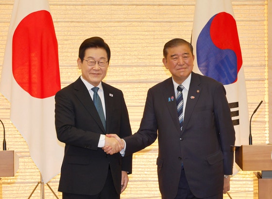 韓国の李在明（イ・ジェミョン）大統領（左）が昨年8月23日、石破茂・当時首相と韓日共同記者発表で会い、握手している。この席で両国は経済安保を含む意思疎通を強化することにした。大統領室写真記者団