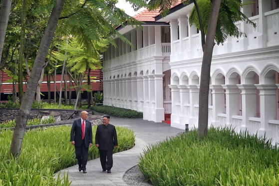 2018年6月12日、シンガポールで開かれた朝米首脳会談で、北朝鮮の金正恩（キム・ジョンウン）国務委員長（右）とトランプ米大統領が会談場所のセントーサ島のカペラホテル周辺を散歩している。［EPA＝聯合ニュース］