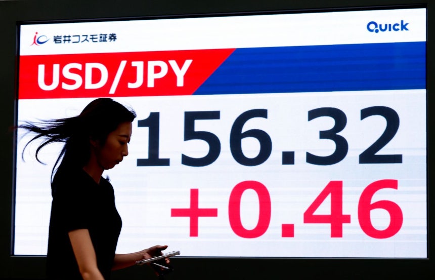  4日、東京で市民が為替相場を示すモニターの前を通り過ぎている。日本銀行の利上げ観測の中で円は1ドル＝156円台まで上がっている。［写真 EPA＝聯合ニュース］
