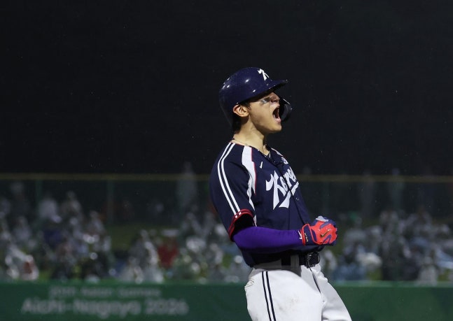 27日のアジア大会野球決勝で日本を相手に決勝打を放った後、雄たけびを上げる金倒永（キム・ドヨン）。韓国は2日前の敗戦の雪辱を果たし、5大会連続で金メダルを獲得した。［聯合ニュース］