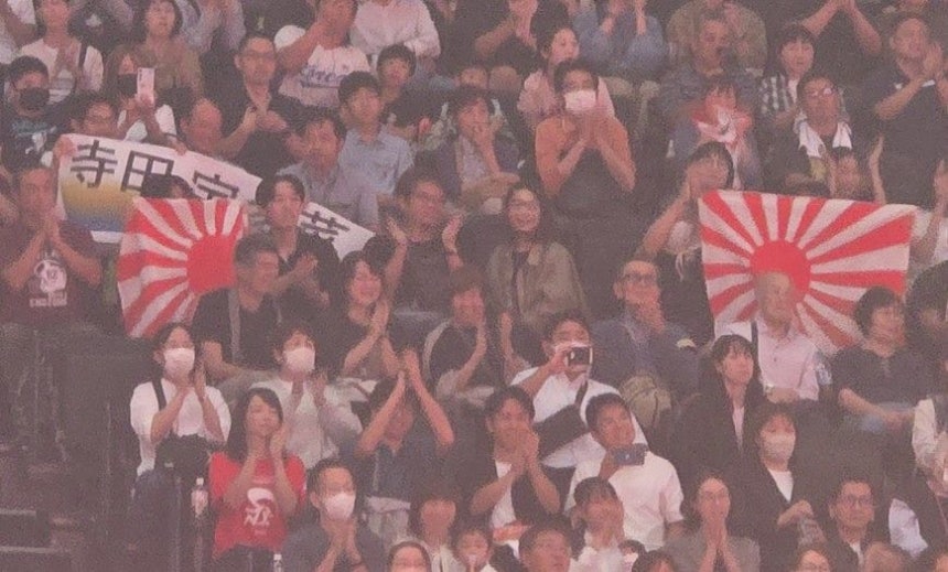 日本の観衆が3日、愛知国際アリーナで開かれた愛知・名古屋アジア大会柔道混合団体戦日本とカザフスタンの決勝戦で旭日旗を持って応援している。［写真 柔道関係者］