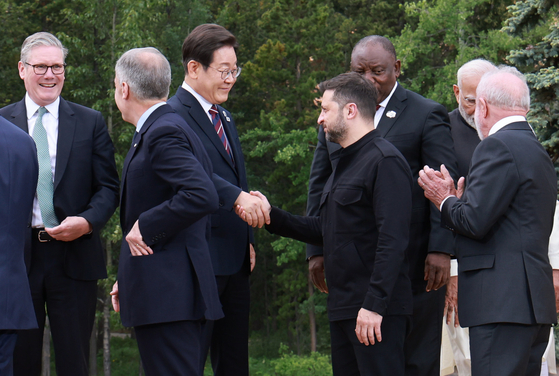昨年6月17日（現地時間）、カナダ・アルバータ州カナナスキスで開催された主要7カ国（G7）首脳会議の会場で、記念撮影後にウクライナのゼレンスキー大統領と握手する李在明（イ・ジェミョン）大統領 ［大統領室写真記者団］