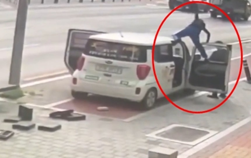 弁当配達員の車の上に上がり、暴れる女性。［写真 SNS］