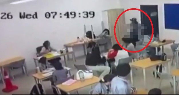マレーシア・サラワク州クチンのインターナショナルスクールで、16歳の男子生徒（赤い円）が、おのを持って教室に入ってきている。［Xアカウント「@surajit_ghosh2」キャプチャー］