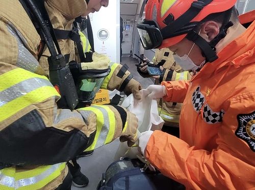  発熱したモバイルバッテリーを確認する消防隊員。［写真 済州道消防安全本部］