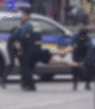 警察官に抱えられて運ばれる女性。［聯合ニュース］