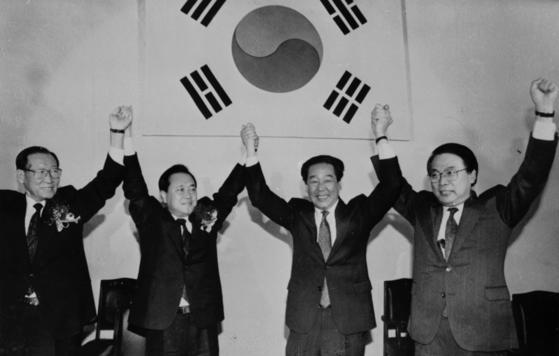 　「統一国民党」鍾路（チョンノ）地区党委員会結成大会で手を取り合うチェ・ブラムさん（左から2人目）。［写真 中央フォト］